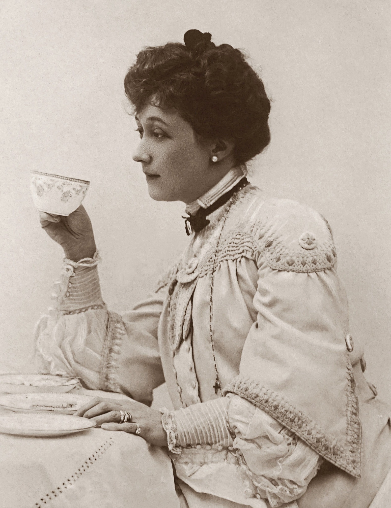 Vintage black-and-white portrait of a woman thoughtfully sipping tea